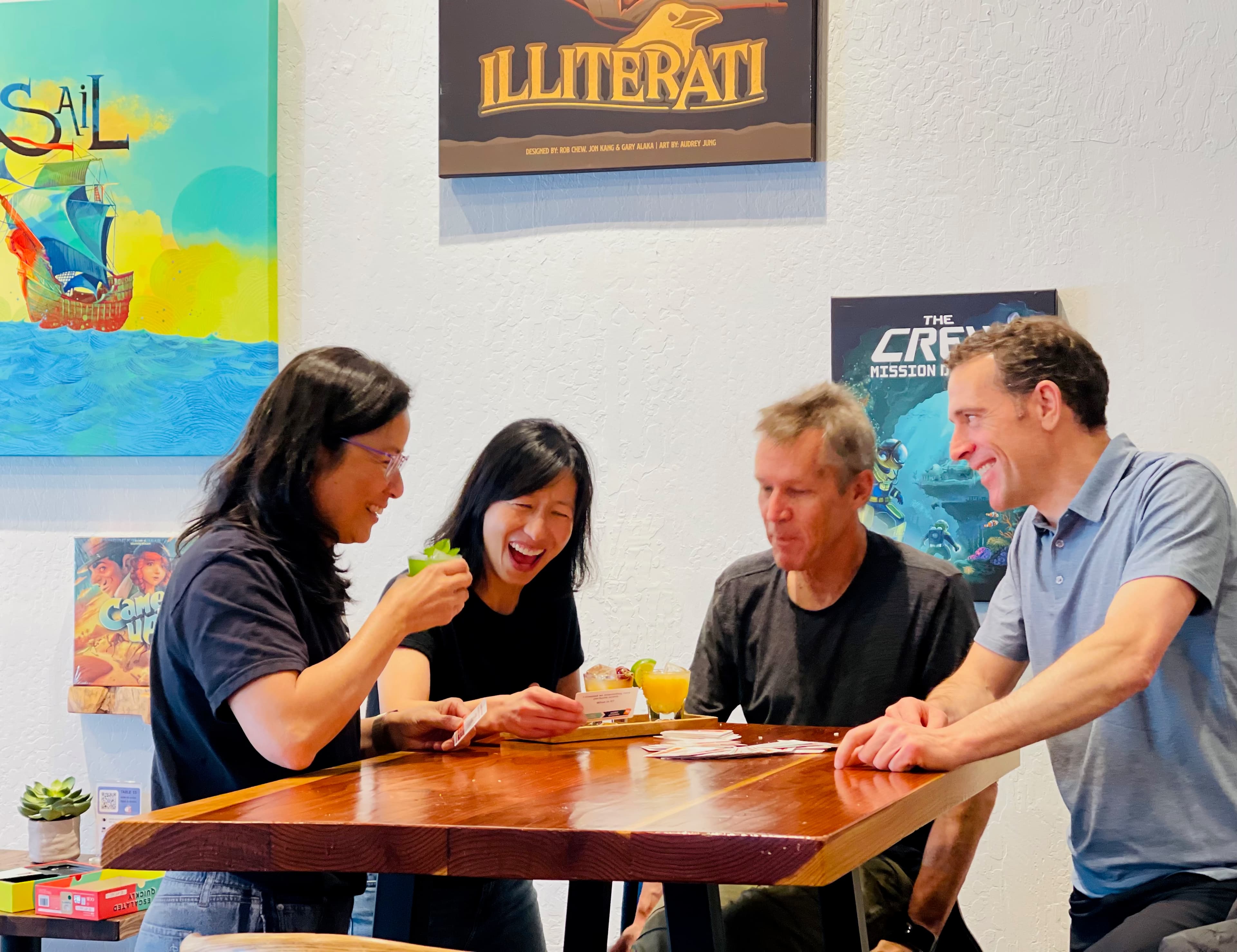 Four friends cracking up over a card game